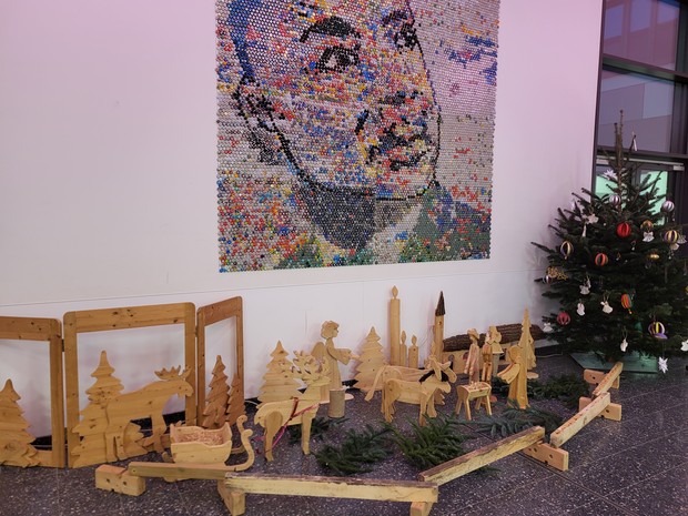 Krippe mit Weihnachtsbaum, im Hintergrund ein Bild von Martin-Luther-King