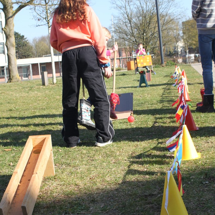 Eine Schülerin steht neben geschmückten Verkehrshütchen und wartet auf eine andere Schülerin, die verkleidet ist. (vergrößerte Bildansicht wird geöffnet)