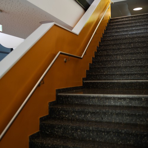 Foto einer Treppe aufwärts. Im Hintergrund Sieht man das Portrait von Martin Luther King.