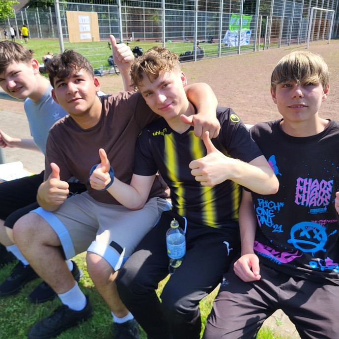 Vier Schüler auf einer Bank mit dem Daumen hoch. (vergrößerte Bildansicht wird geöffnet)