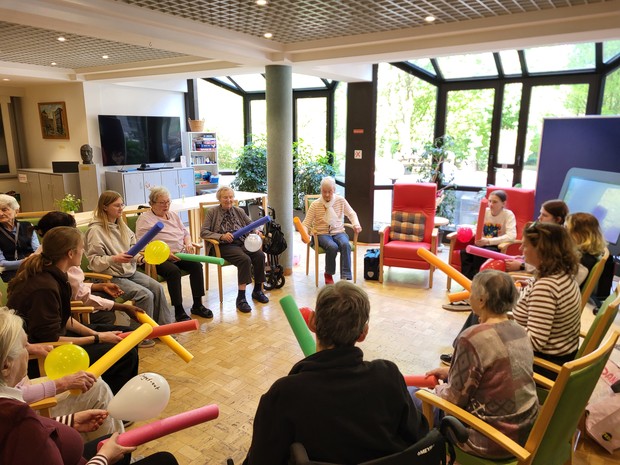 Sitzrunde mit jungen und alten Menschen