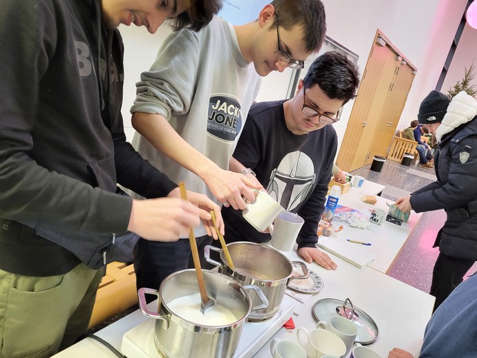Drei Schüler kochen Kakau.
