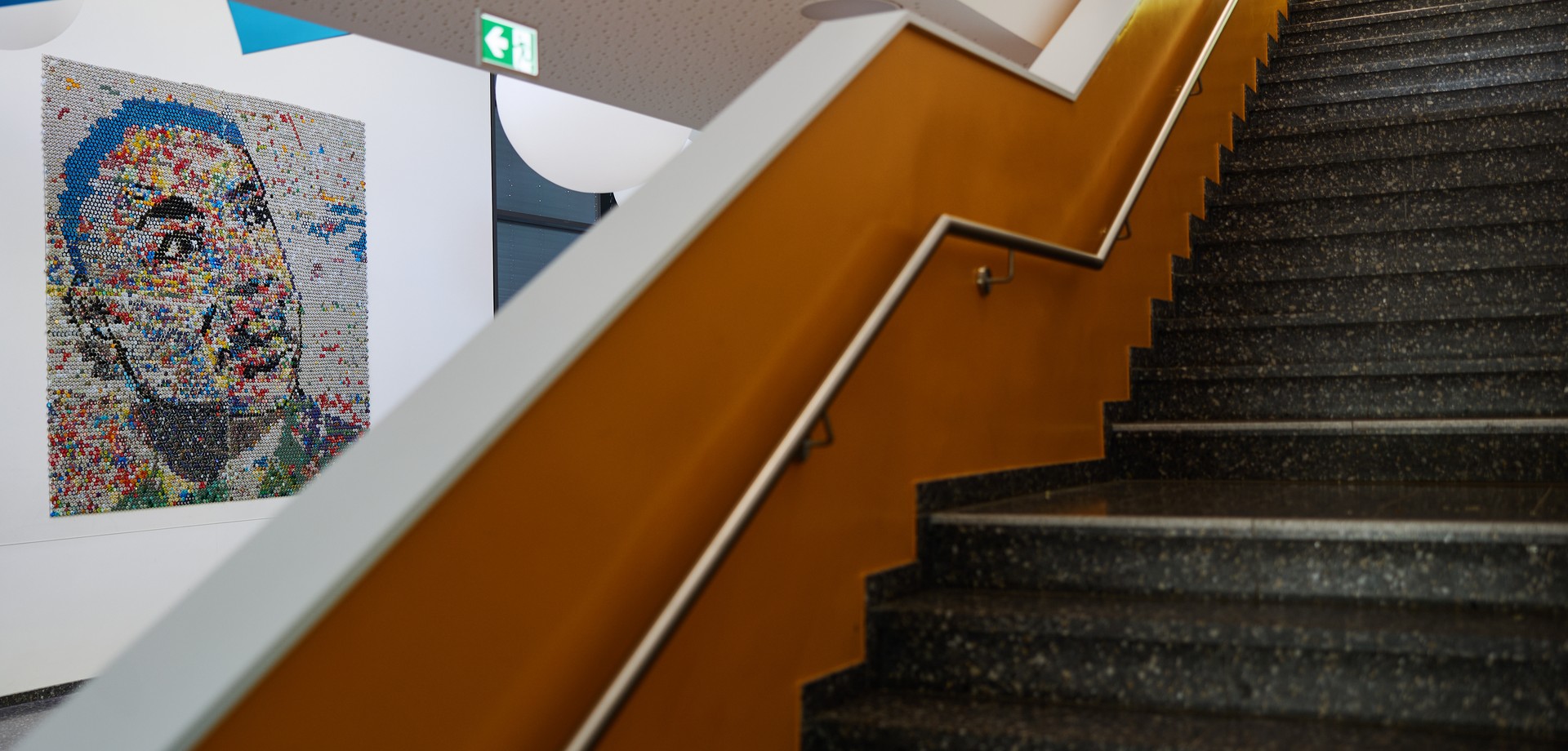 Eine Treppe aufwärts im Schulgebäude, dahinter sieht man das gemeinsam gestaltete Portrait von Martin Luther King an der Wand