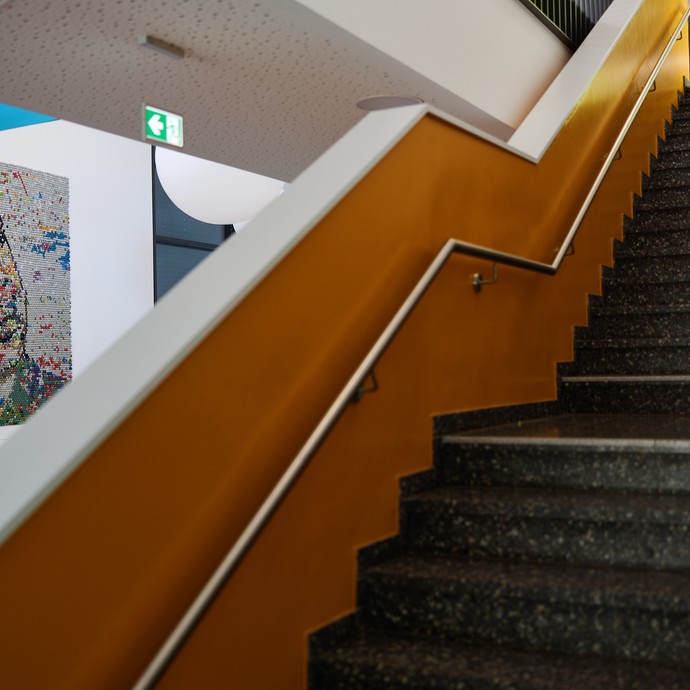 Eine Treppe im Schulgebaude. Dahinter sieht man das Portrait von Martin Luther King an der Wand. (vergrößerte Bildansicht wird geöffnet)