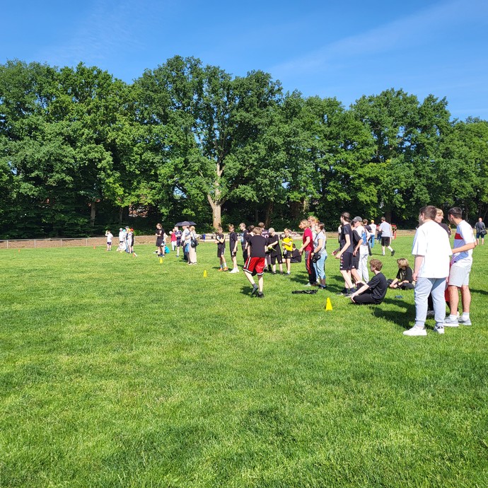 Zuschauer  hinter der Abtrennung und Fußballspielende davor. (vergrößerte Bildansicht wird geöffnet)