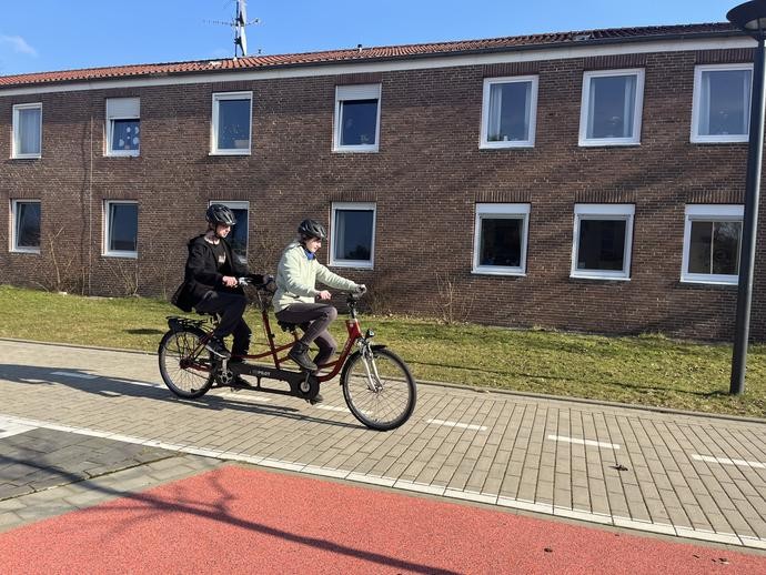Zwei Lernende fahren auf einem Tandem.