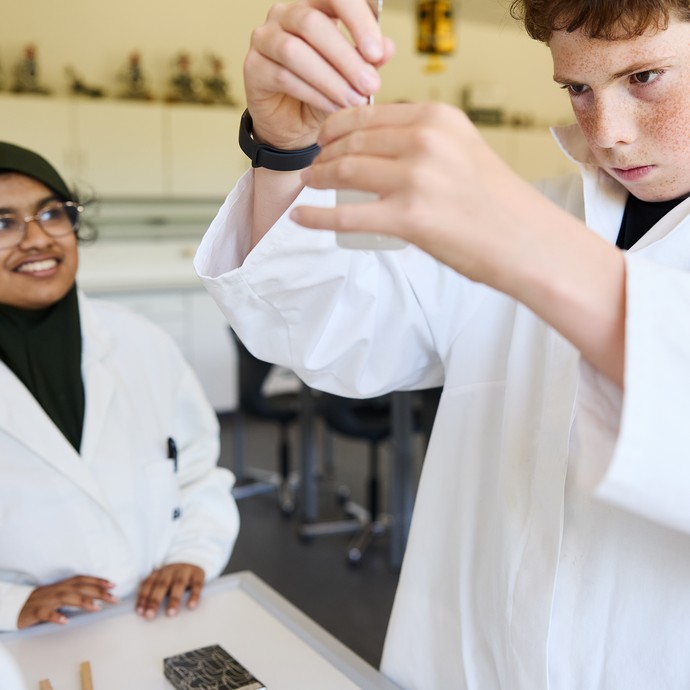 Ein Schüler führt einen chemischen Test durch. Eine junge Frau beobachtet dies. (vergrößerte Bildansicht wird geöffnet)